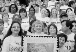 Beverly Dalton, Team USPS captain and longtime breast cancer survivor, holds a Breast Cancer Research stamp poster with 1,316 colleagues...